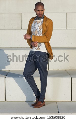 Full length portrait of a handsome male fashion model standing outdoors