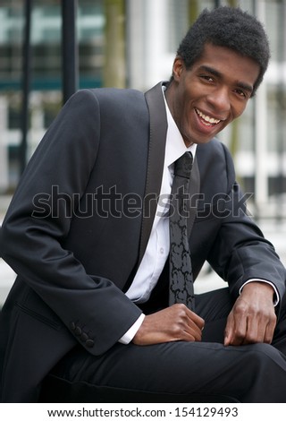 Closeup portrait of a handsome man sitting outdoors in business suit