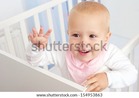 Closeup portrait of a cheerful baby waving hello