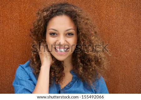 Closeup portrait of an attractive young woman smiling with hand in hair