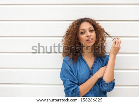 Horizontal portrait of a beautiful young woman looking at camera with hand in hair