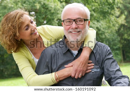 Close up portrait of a happy senior man and beautiful older woman smiling together