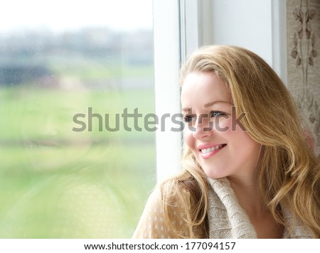 Close Up Portrait Of A Smiling Woman Looking Outside Through Window