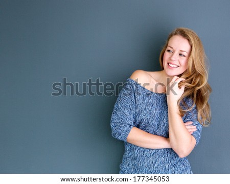 Close up portrait of a young woman smiling with hand in hair
