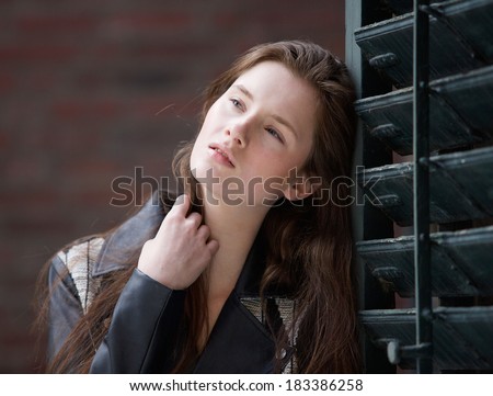 Close up portrait of a beautiful young woman thinking with hand in hair