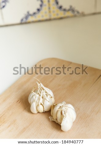 Close up garlic cloves on wooden chopping board in kitchen