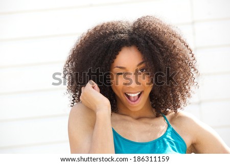 Close up portrait of a cute young woman winking eye smiling and flirting