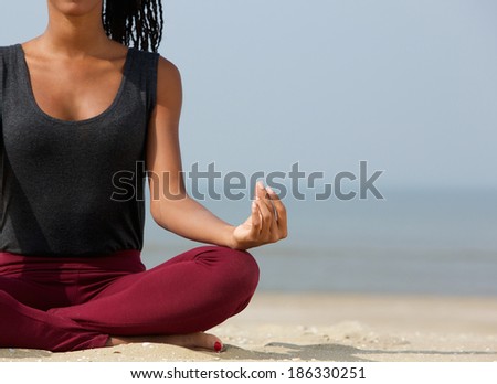 Close up portrait of a young woman in lotus position with yoga hands at the beach
