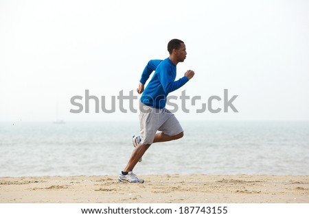 Young male jogger exercising at the beach in sportswear