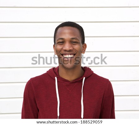 Close up portrait of a handsome young black man smiling on white background
