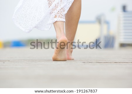 Close up low angle barefoot woman walking away