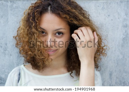 Close up portrait of an elegant young woman posing with hand in hair