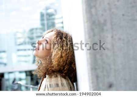Close up portrait of a beautiful young woman looking up and thinking outdoors