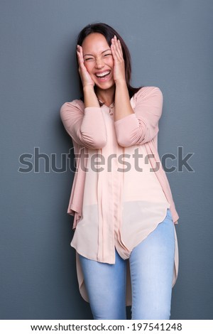 Portrait of a young woman laughing with embarrassed expression