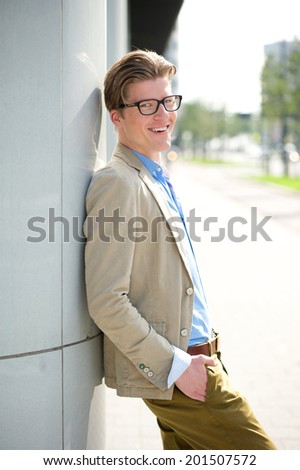 Portrait of a handsome young man with glasses smiling outdoors