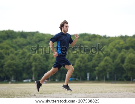 Profile of a young man jogging outdoors in park