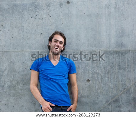 Portrait of a cool guy in blue shirt laughing outside