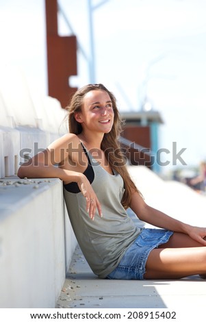 Portrait of a beautiful young woman sitting outside on steps