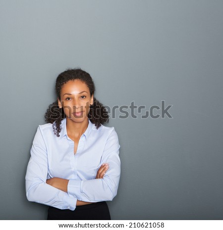 Close up portrait of a female business person with arms crossed on gray background