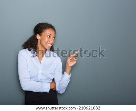 Close up portrait of a happy business woman pointing finger on gray background