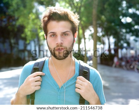 Close up male student walking outdoors with bag