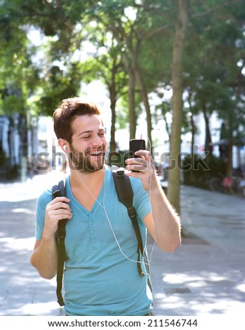 Portrait of a young man smiling and holding mobile phone