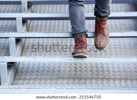 Close up front view of man in leather shoes walking downstairs