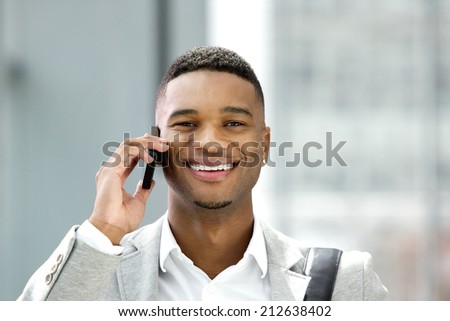 Close up portrait of a handsome young man smiling with mobile phone