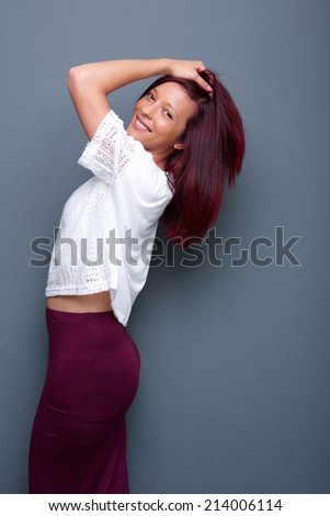 Portrait of a beautiful young mixed race woman smiling with hand in hair