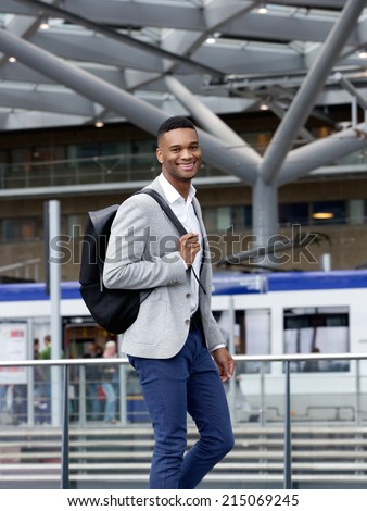 Portrait of a cool guy smiling with bag at station