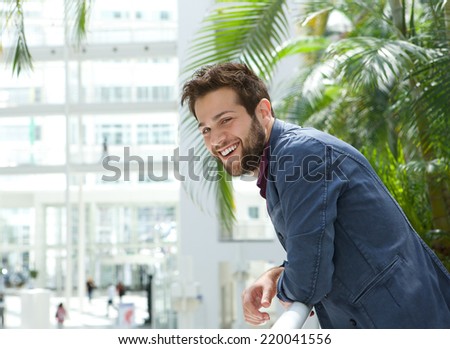 Close up portrait of a happy man leaning inside bright building