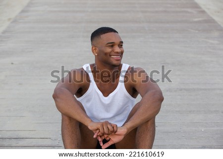 Portrait of a cool guy smiling and sitting outdoors