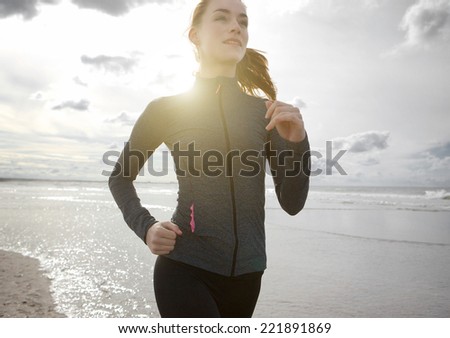 Close up portrait of a woman jogging outdoors by the beach