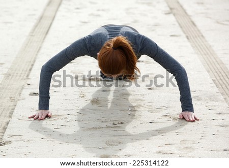 Low angle of young woman doing push ups at beach