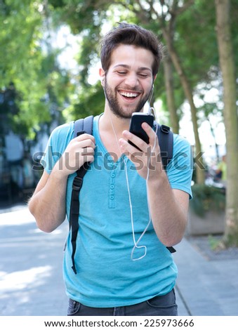 Portrait of a young man smiling and looking at mobile phone