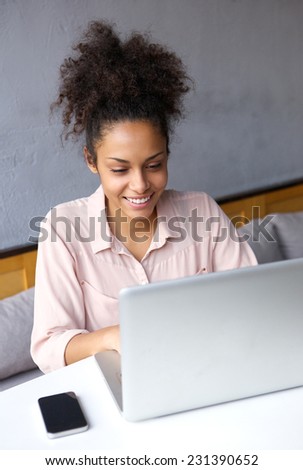 Portrait of a happy young business woman working on laptop
