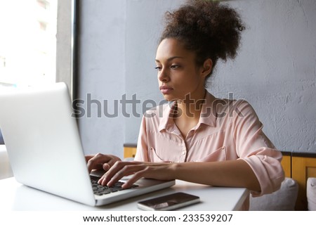 Close up portrait of a young woman working on laptop