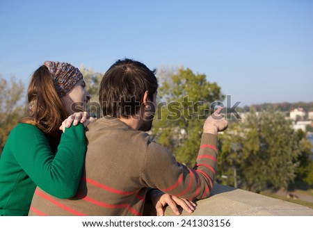 Close up portrait from behind of a young couple with man pointing finger