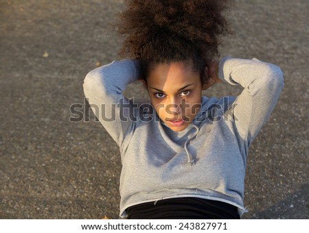 Young african american woman doing sit ups outdoors
