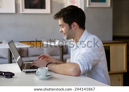 Portrait of a happy young man working on laptop