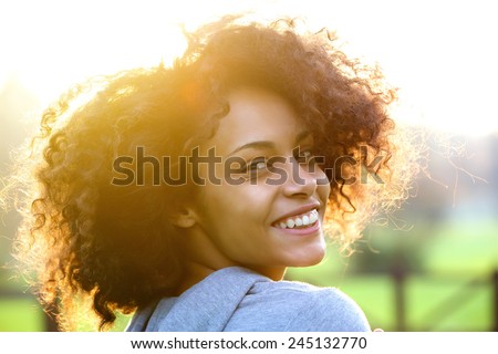 Close up portrait of a cheerful young african american woman smiling outdoors