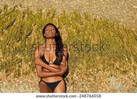 Portrait of an african woman in black bikini with arms crossed