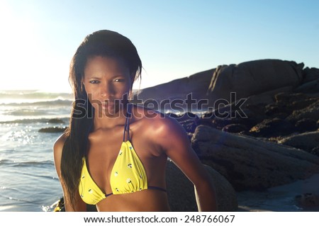 Close up portrait of a sexy african american woman in yellow bikini at the beach