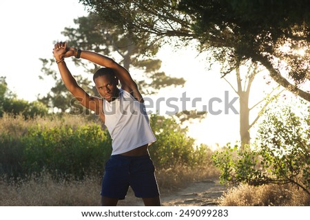 Portrait of a young african american man stretching muscles workout