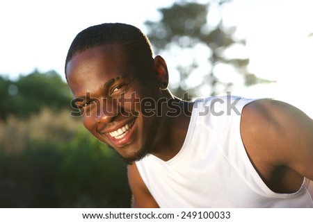 Close up portrait of a happy young black man smiling outdoors