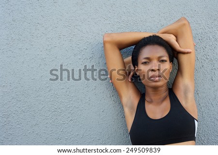 Close up portrait of a beautiful black fitness woman posing against gray background