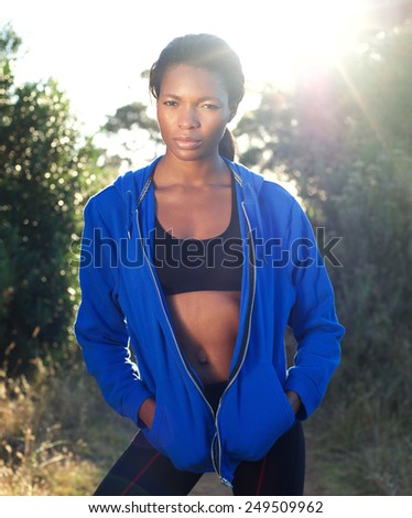 Portrait of a beautiful african american sports woman standing outdoors in blue sweatshirt