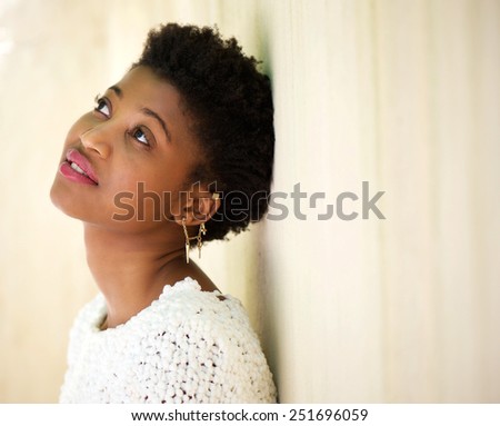 Close up profile portrait of a young black woman looking up and thinking