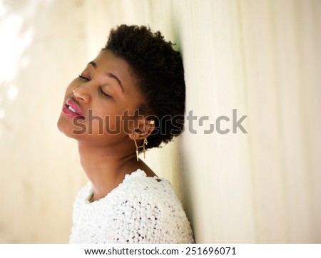 Close up portrait of a young black woman resting with eyes closed