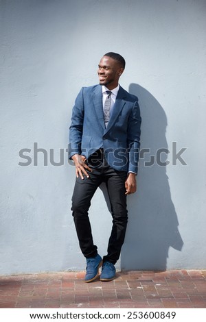 Full body portrait of a smiling business man standing against gray background